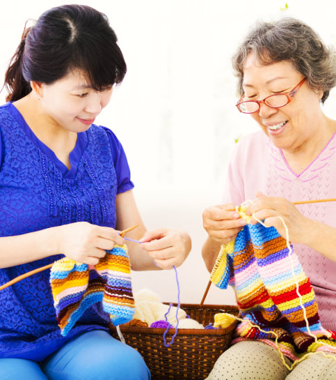 caregiver and senior woman sewing