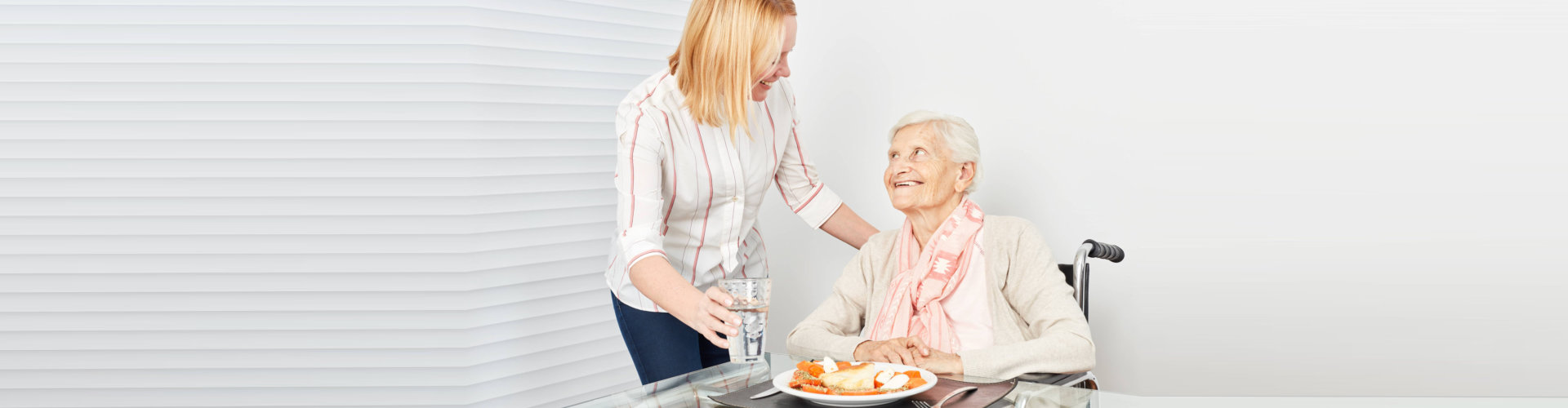 caregiver and elderly having a meals